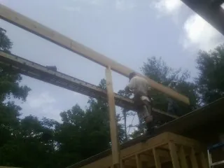 Carpenter setting a ridge beam over a new addition frame — Ice Dam Removal by Roofing Brothers in Bloomsbury