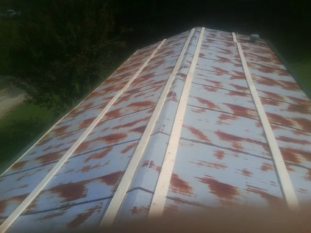 Rusted metal roof panels with new wood purlins before replacement — Storm Damage Roof Repair in Bloomsbury by Roofing Brothers
